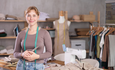 Young female dressmaker welcoming clients in sewing workshopの写真素材