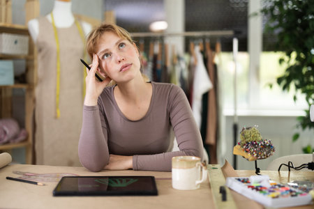 Tired dressmaker worker at table