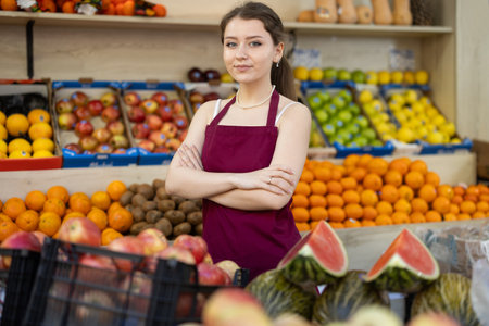 Portrait of female seller in apron in interior of grocery supermarketの写真素材