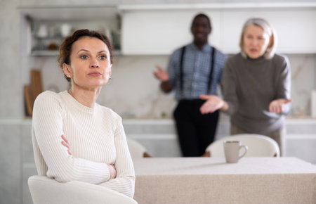 Woman not talking after disagreement with husband and mother standing behind