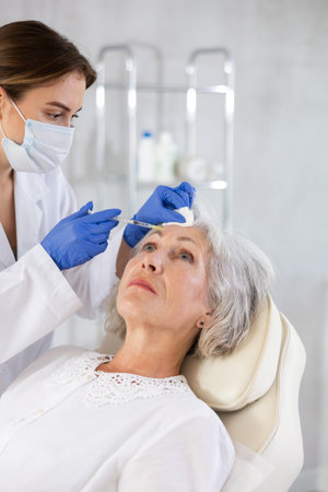 Elderly patient getting forehead fillersの写真素材