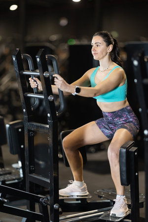 Woman uses leg abduction machine to strengthen muscles