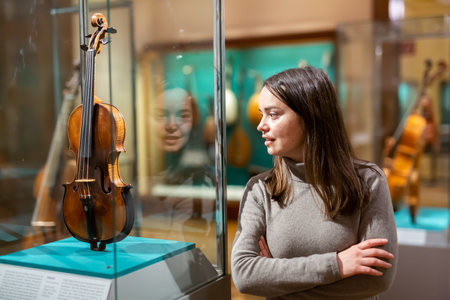 Interested brunette visiting exhibition of medieval musical instruments in museumの写真素材