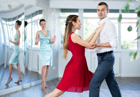 Couple in stage costumes learns waltz dancing during individual lesson