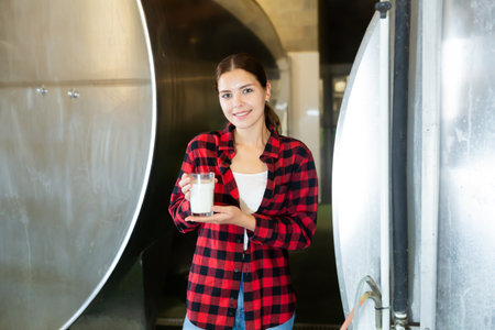 Portrait of a positive young girl holding a glass of milkの写真素材