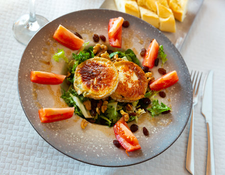 Salad with toasted goat cheese with fresh vegetables, greens, nutsの写真素材