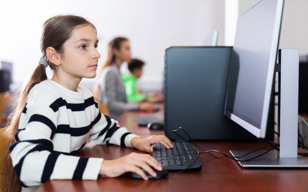 Teen schoolgirl learning basics of programming in computer collegeの写真素材