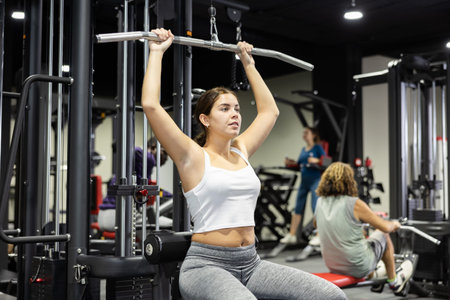 Athletic young woman works out on simulator