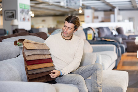 Middle-aged man chooses upholstery color of furnitureの写真素材