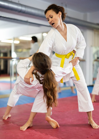 Womens practicing new karate moves in pairs in class with trainerの写真素材