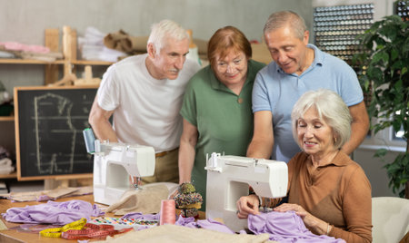 Elderly female teacher shows master class on sewingの写真素材