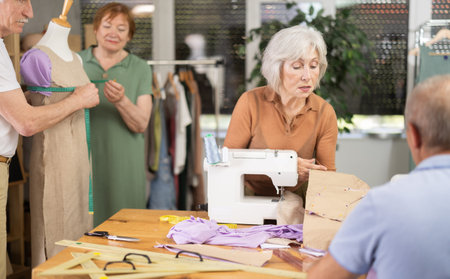 Instructor of tailoring course for seniors reviewing patterns with participant