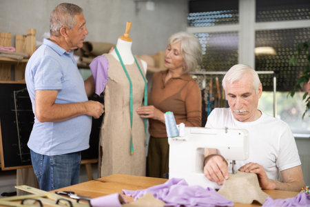 Older adults gathering at sewing course in small studioの写真素材