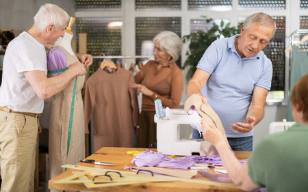 Instructor of tailoring course for seniors reviewing patterns with participant