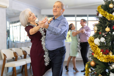In studio decorated for New Year, elderly man and woman perky dance pair discofox.の写真素材