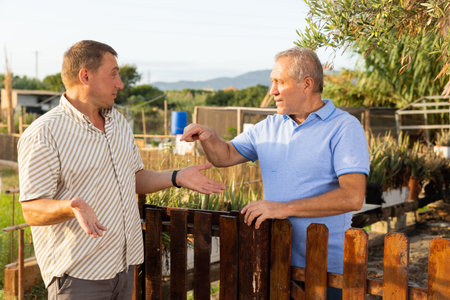 Neighbors arguing at fence outdoors