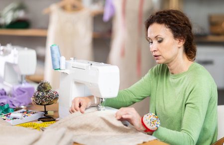Woman tailor at work in cloth design shopの写真素材