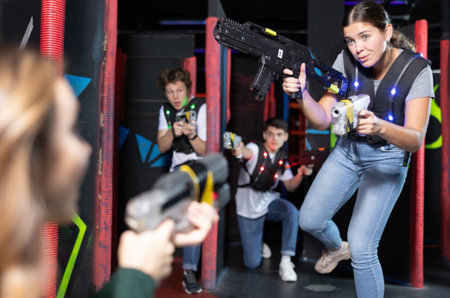 Young lady having fun playing lasertag in arenaの写真素材