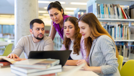 Female and male colleagues working together in public libraryの写真素材