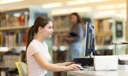 Female student works at computer in library