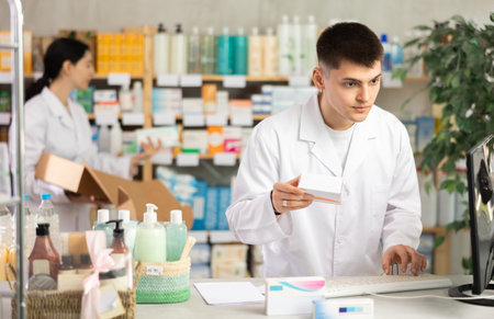 Portrait of male pharmacist working at computer in pharmacyの写真素材