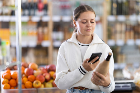 Woman scanning a bottle of wineの写真素材