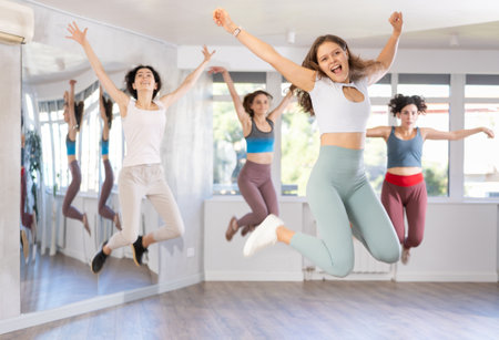 Cheerful girl captured jumping during lively dance fitness routineの写真素材