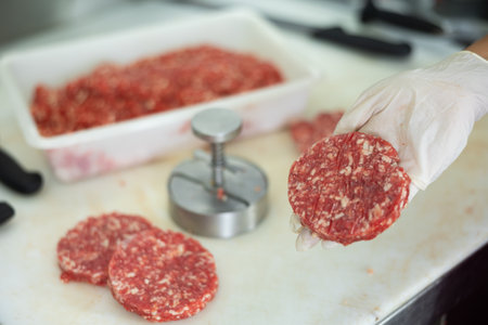 Cooking meat cutlets in kitchen using special devicesの写真素材