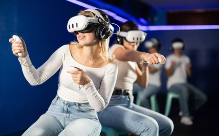 Two girls wearing virtual reality glasses participate in game with opponents