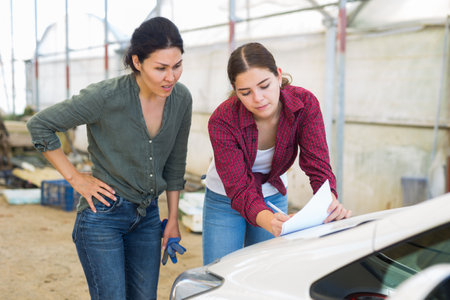 Two women farmers sign documents in the backyard of farmの写真素材