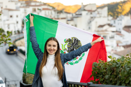 Hapy footbal fan woman waving the flag of Mexican on streetの写真素材