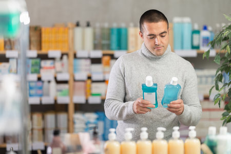 Man choose mouthwash in pharmacyの写真素材