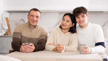 Portrait of happy family - married couple and father at homeの写真素材