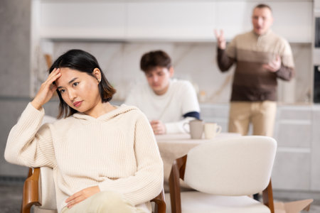 Adult and young man quarreling with womanの写真素材