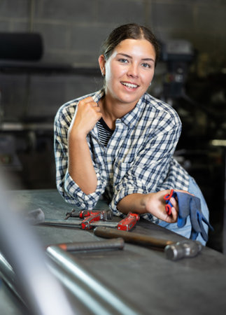 Young woman posing in metallurgical workshopの写真素材