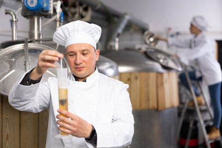 Portrait of expert who is checking beer in the laboratory of brew-house.の写真素材