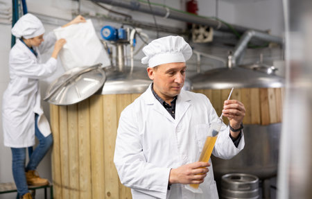 Brewer checks amount of alcohol in beer using an alcoholmeterの写真素材