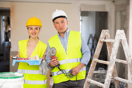 Two workers posing on indoor construction siteの写真素材