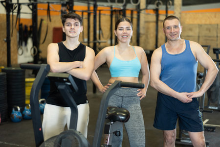 Smiling confident sporty people standing in modern gym