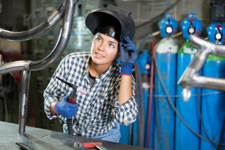 Young woman working with welding machineの写真素材