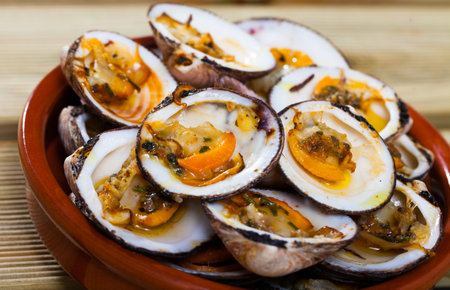 Deliciously seafood with baked in oven open seashell at plate on tableの写真素材