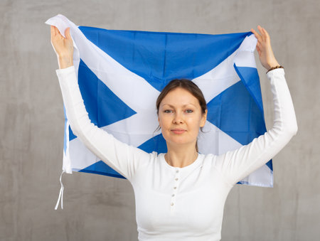 Excited woman with Scotland flag rooting for your favorite teamの写真素材