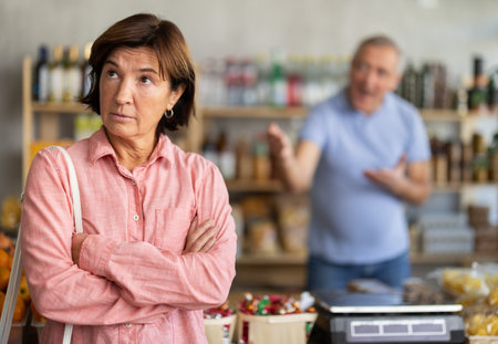 Family quarrel between elderly husband and wife in grocery supermarket. Husband screams at her wifeの写真素材