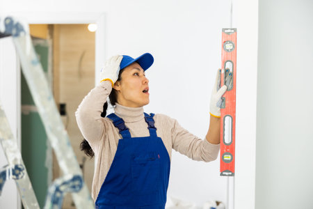 Woman builder is unhappy with the way the hired workers leveled the wall in house