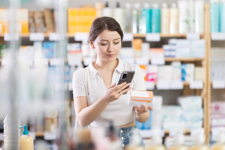 Young woman scanning qr code of pillsの写真素材