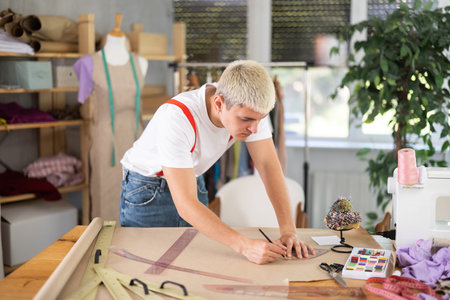 Male fashion designer draws with curved rulers