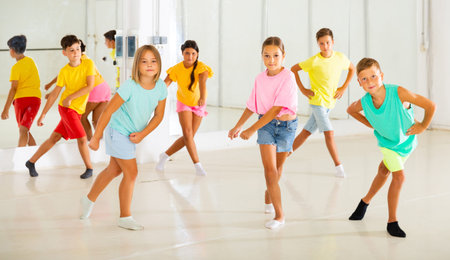 Children studying modern style dances in class indoors