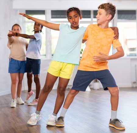 Active multinational children enjoying of partner dance in in dance studioの写真素材