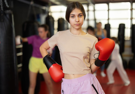 Teenage girl with boxing gloves in gymの写真素材