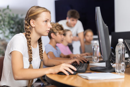 Portrait of female schoolgirl at computers in computer classの写真素材